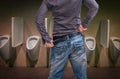 Standing man peeing to a urinal in restroom Royalty Free Stock Photo