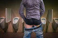 Standing man peeing to a urinal in restroom Royalty Free Stock Photo