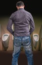 Standing man peeing to a urinal in restroom Royalty Free Stock Photo