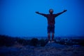 Standing man on top of a cliff with arms raised at night landscape mountain Royalty Free Stock Photo