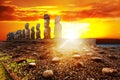 Standing moais in Easter Island in dramatic orange sunset Royalty Free Stock Photo