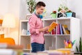 Student standing near bookcase and choosing the book to read Royalty Free Stock Photo