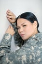 Servicewoman wearing military uniform standing near wall