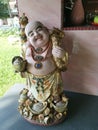 A standing old porcelain Buddha statue of Budai at the corridor entrance of the home