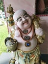 A standing old porcelain Buddha statue of Budai at the corridor entrance of the home
