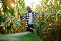 Standing and posing. Young black man is in the cornfield at daytime Royalty Free Stock Photo