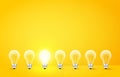Standing in a row light bulbs with glowing one on yellow background. Unlike others or odd man out concept. Vector Royalty Free Stock Photo