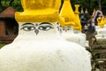 Standing in a row of white stone pillars with images on them the eyes of the Buddha. Royalty Free Stock Photo