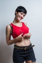 Standing short-hair brunette woman wearing a red tank top, smiling. Royalty Free Stock Photo