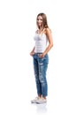 Standing teenage girl in jeans and white singlet, isolated