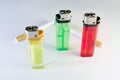 standing three multicolored disposable flint gas lighters and two filter cigarettes Royalty Free Stock Photo