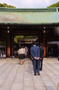 Standing in two lines in front of the entrance of a shrine.