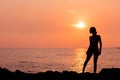 Standing woman silhouette on sea background back lit Royalty Free Stock Photo