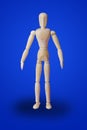 Standing wooden toy figure on blue
