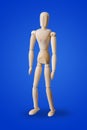 Standing wooden toy figure on blue