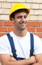 Standing worker in front of a brick wall