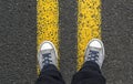 Standing on yellow street lines.