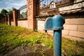 Standpipe on the street a flowing stream of water on a a fence and a building Royalty Free Stock Photo