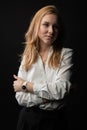 stands on a black background in a white blouse. with beautiful eyes,, in the studio, business woman, blonde Royalty Free Stock Photo