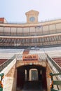 Stands with an emergency exit and the ancient clock of a Spanish arena