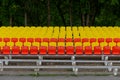 Stands of a small stadium with rows of yellow and red seats Royalty Free Stock Photo