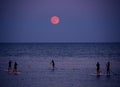 Standup paddleboarding under full moon