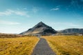 Stapafell volcanic mountain in Arnarstapi fishing village and pathway through golden meadow at Iceland