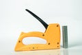 yellow gun tacker with staples, on white background and reflection Royalty Free Stock Photo
