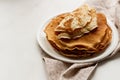 Staple of wheat golden yeast pancakes or crepes in a white plate closeup