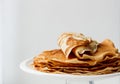 Staple of wheat golden yeast pancakes or crepes in a white plate closeup on a white background