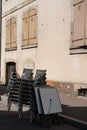 Stapled chairs and tables of a closed terrace restaurant with copy space in Colmar, France.