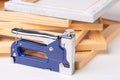 A stapler gun for canvas stretching, wooden frames and a finished canvas in the background. The production process of printed Royalty Free Stock Photo