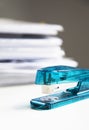Stapler on white table with stack of papers in background Royalty Free Stock Photo