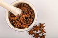 Star anise in a blue ceramic spice mortar with a pestle on a white background. Close up Royalty Free Stock Photo