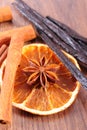 Star anise, fragrant vanilla, cinnamon and dried orange on wooden surface Royalty Free Stock Photo