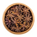 Star anise seeds in a wooden bowl over white Royalty Free Stock Photo