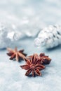 Star anise and silver Christmas baubles on bright wooden background. Royalty Free Stock Photo