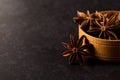 Star anise in a wooden bowl on a black table. Concept, copy space Royalty Free Stock Photo