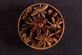 Star anise in a wooden bowl on a black table. Concept, copy space Royalty Free Stock Photo