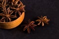 Star anise in a wooden bowl on a black table. Concept, copy space Royalty Free Stock Photo