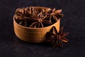 Star anise in a wooden bowl on a black table. Concept, copy space Royalty Free Stock Photo