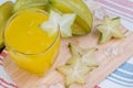 Star apple juice or averrhoa carambola squash on wooden block.