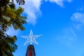 A star atop a Christmas tree, against the blue sky outdoors Royalty Free Stock Photo