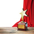 Star award wooden table and on the background of red curtain Royalty Free Stock Photo