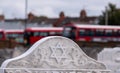 Star of David symbol on gravestone at the Victorian Jewish cemetery in Willesden, north west London. Bus terminal in distance. Royalty Free Stock Photo