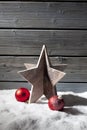 Star decoration red christmas spheres on pile of snow against wooden wall Royalty Free Stock Photo