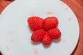 Star shape red strawberry fruit, white plate, close up Royalty Free Stock Photo