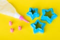 Star shaped cookie cutters. Cake decorating tools, pastry bag with nozzles on a yellow background for cake decorating.