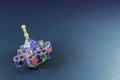 Star shaped enameled Hanukkah dreidel on a blue background with space for text Royalty Free Stock Photo