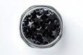Star shaped gummies with black elderberry extract in a glass jar on a white background. View from above